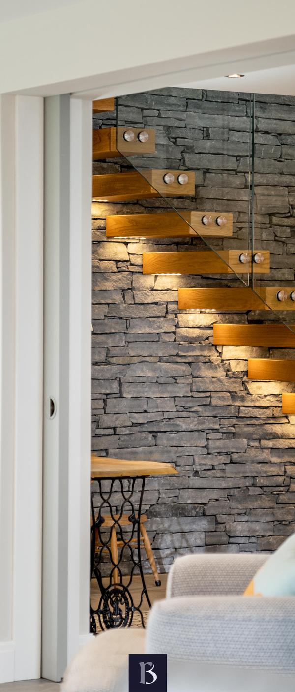 Wooden modern stairs with lighting and stone wall interior